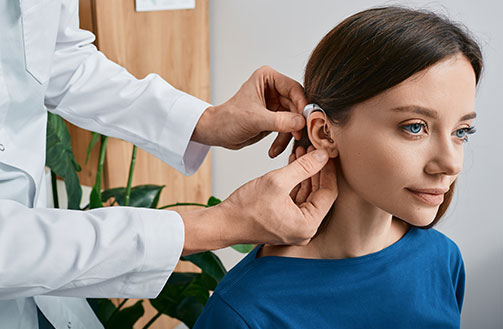 female patient getting hearing aid